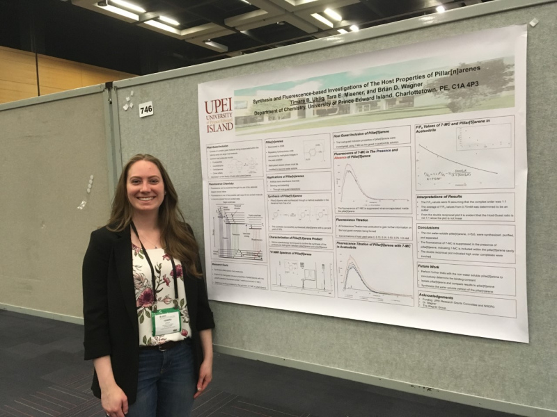 A female student standing in front of a large technical poster