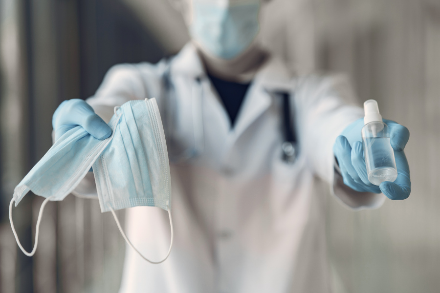 image of someone holding masks, sanitizer