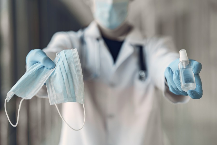 image of person holding mask, sanitizer