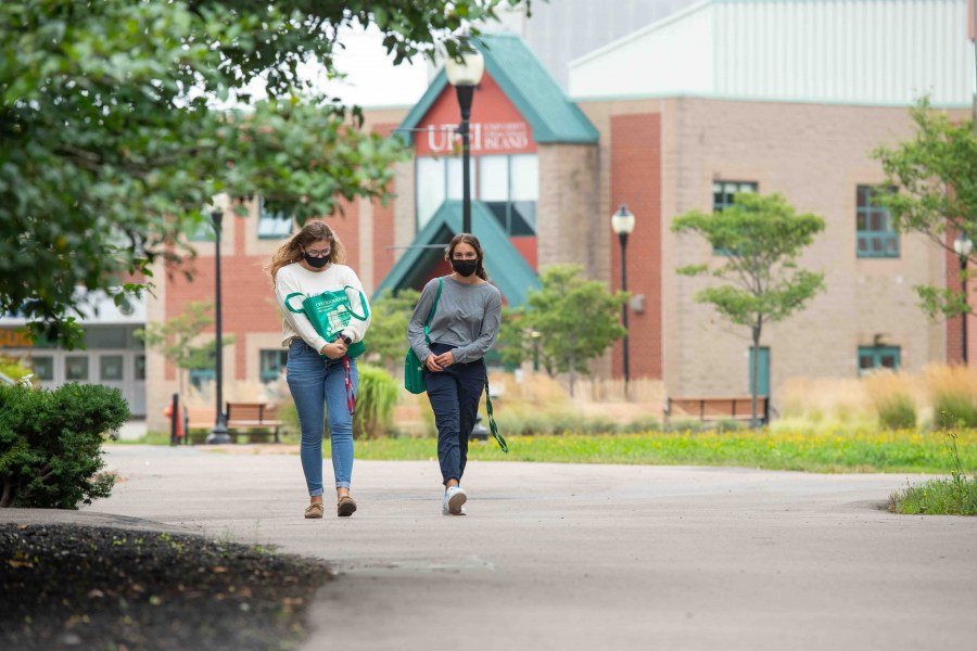 Two women wearing masks walking on the UPEI campus 