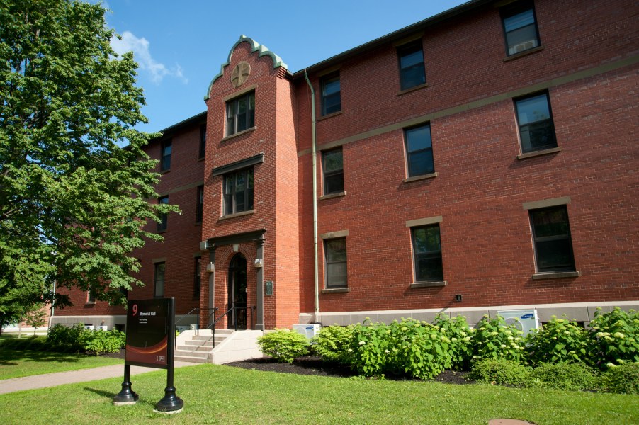 A symmetrical three-story building of brick and stone with a central entrance