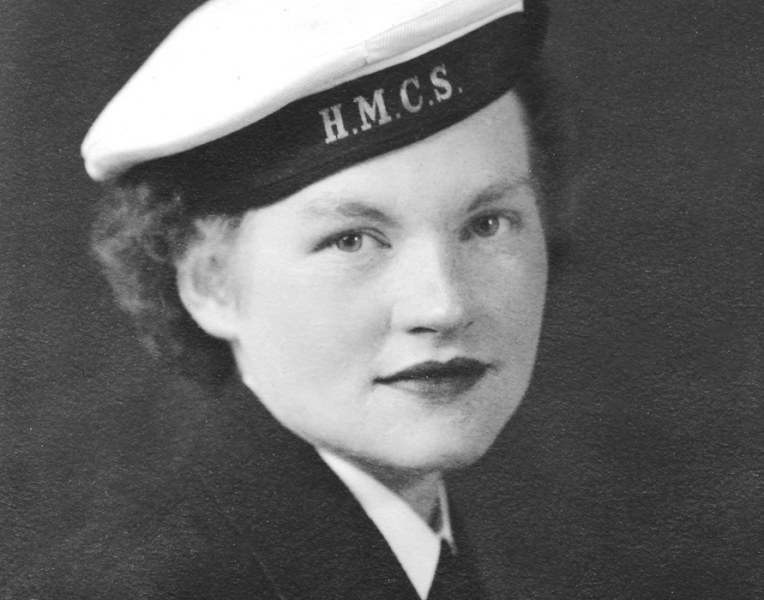 A black and white close-up photo of a woman from the World War II era with a sailor's cap which reads HMCS on the band