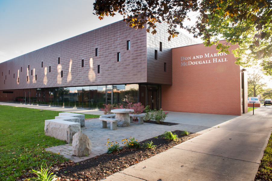 A modern-looking university building with mixed construction of brick, glass, and copper.