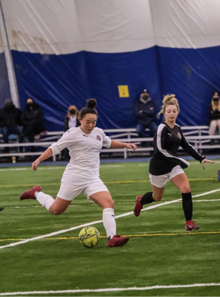 photo of woman kicking soccer ball 