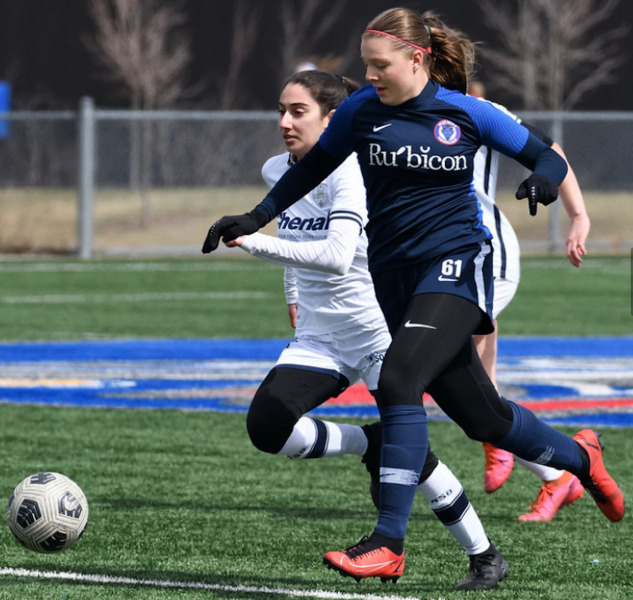 photo of female student athlete dribbling soccer ball