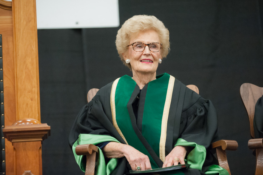 photo of woman sitting down wearing academic regalia