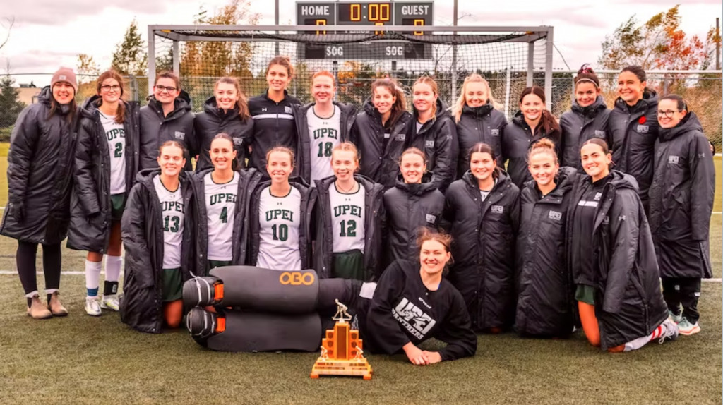 photo of a group of women wearing field hockey uniforms standing on a field