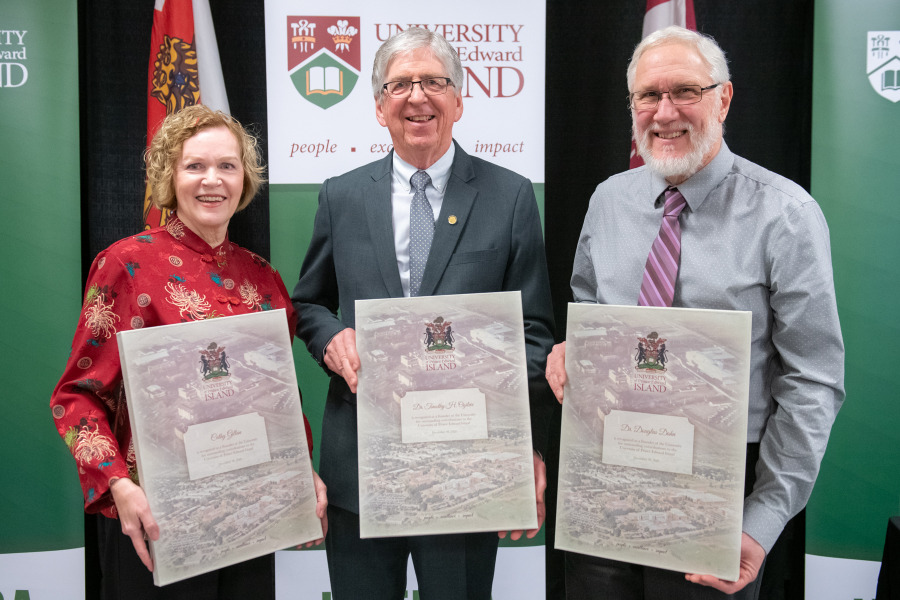 photo of three people holding presentation plaques