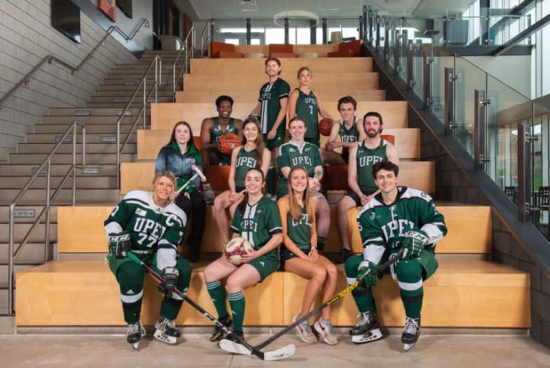 photo of athletes wearing their uniforms sitting on a staircase