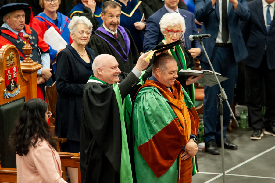 John Horrelt, who received an honorary degree from UPEI during Convocation 2023, receives his hat, part of his academic regalia, from Dr. Greg Keefe, interim president and vice-chancellor.