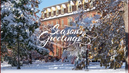 photo of brick building with snow covered trees in foreground