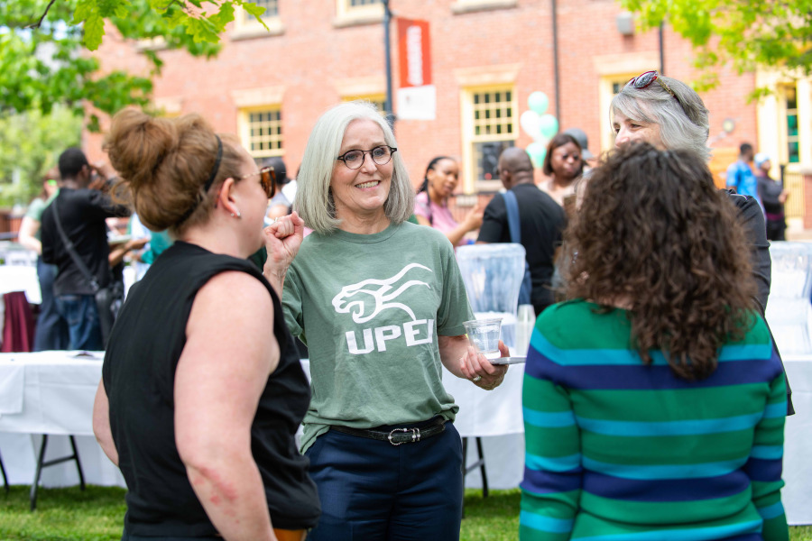 photo of woman speaking to others at an outdoor gathering