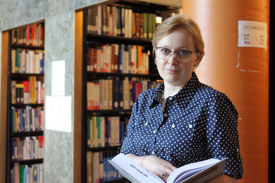 Photo of woman standing in front of book stacks