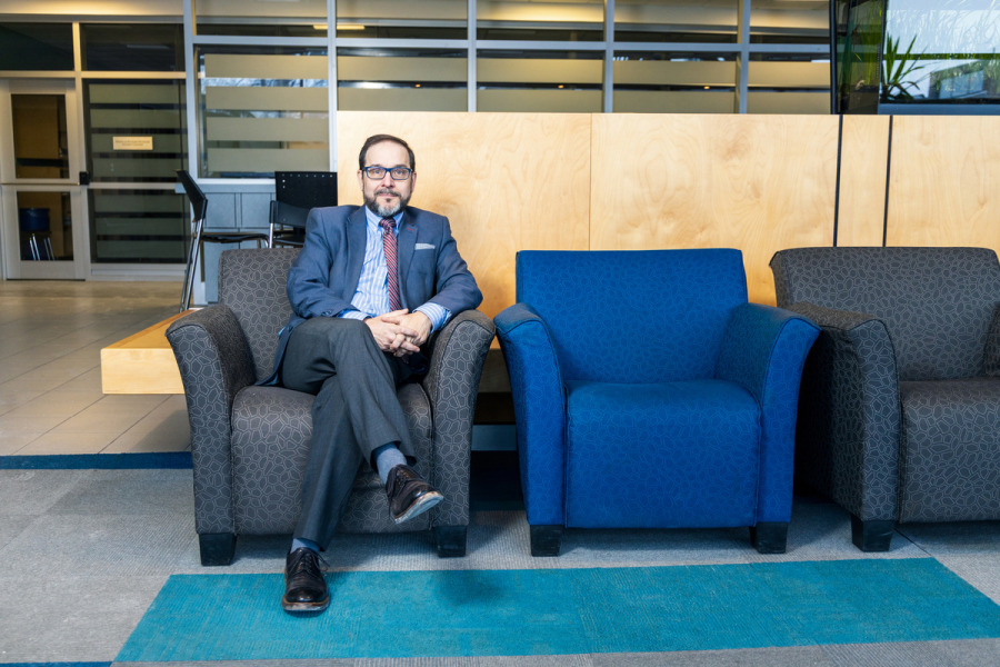 Photo of man sitting in a chair in a common area