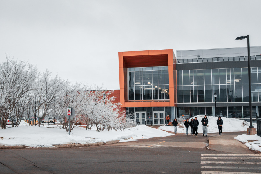 photo of students walking in front of modern campus building