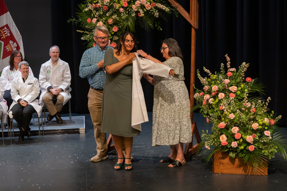 Anya Nowicki receives her white coat from her parents Jacqueline and Daniel Nowicki.
