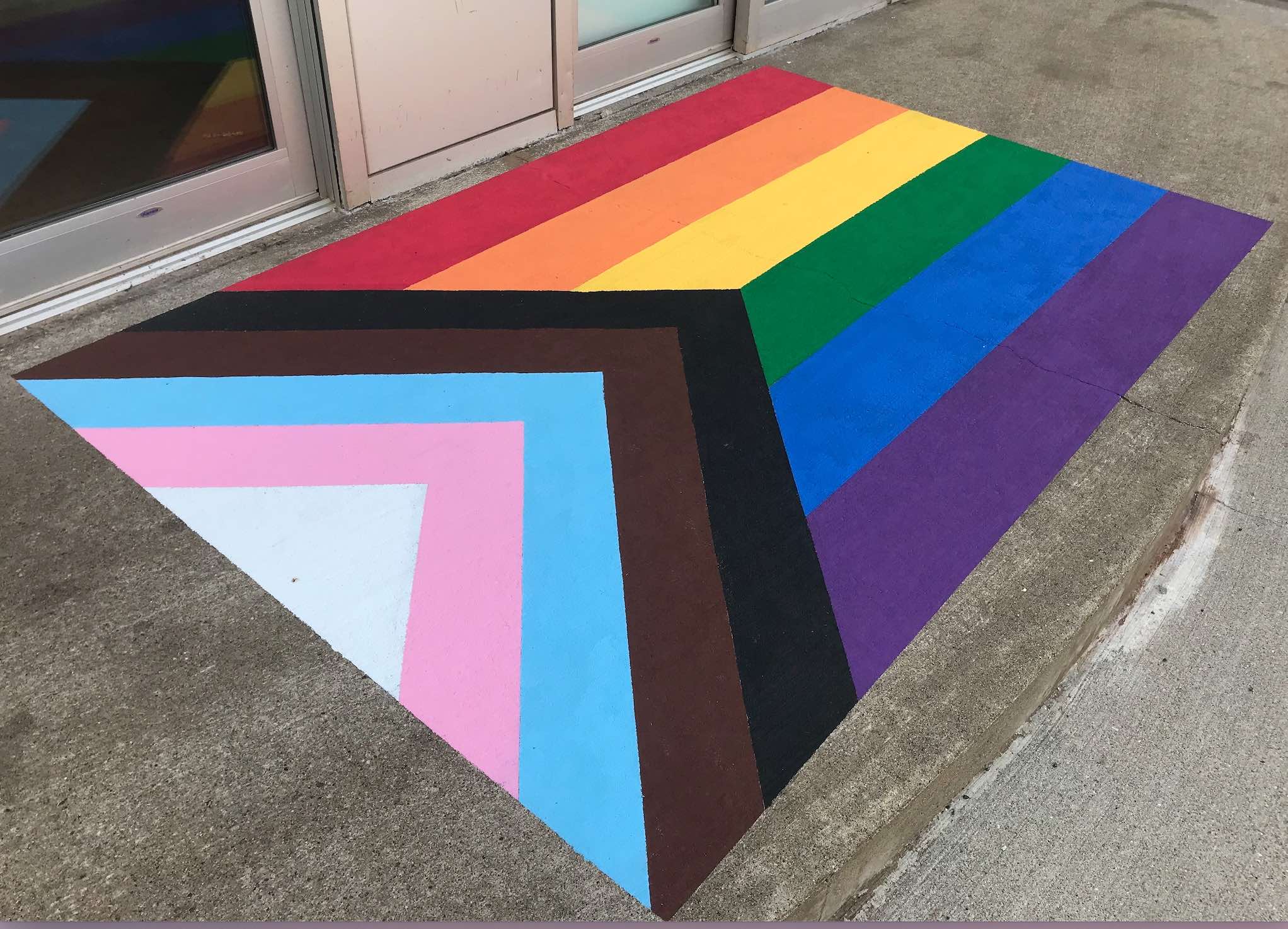 Photo of the Progress Pride Flag, on steps at UPEI