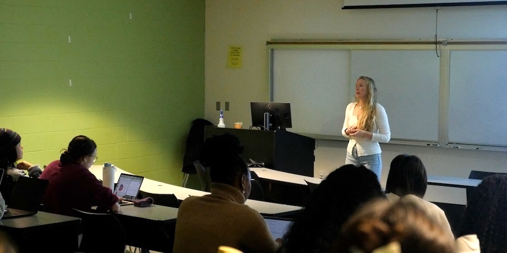 assistant professor Ashton Dougan leading a lecture in a classroom