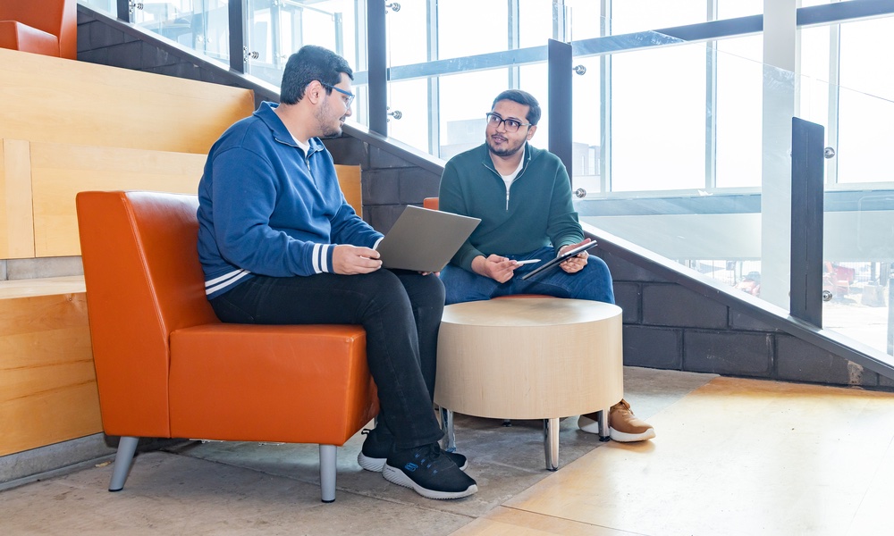 Syed Imran Ali and Syed Daniyal Ali sitting in a lit building atrium