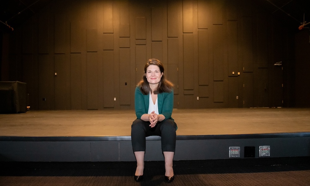 Dr. Magdalena von Eccher sitting on stage in Steel Recital Hall at UPEI