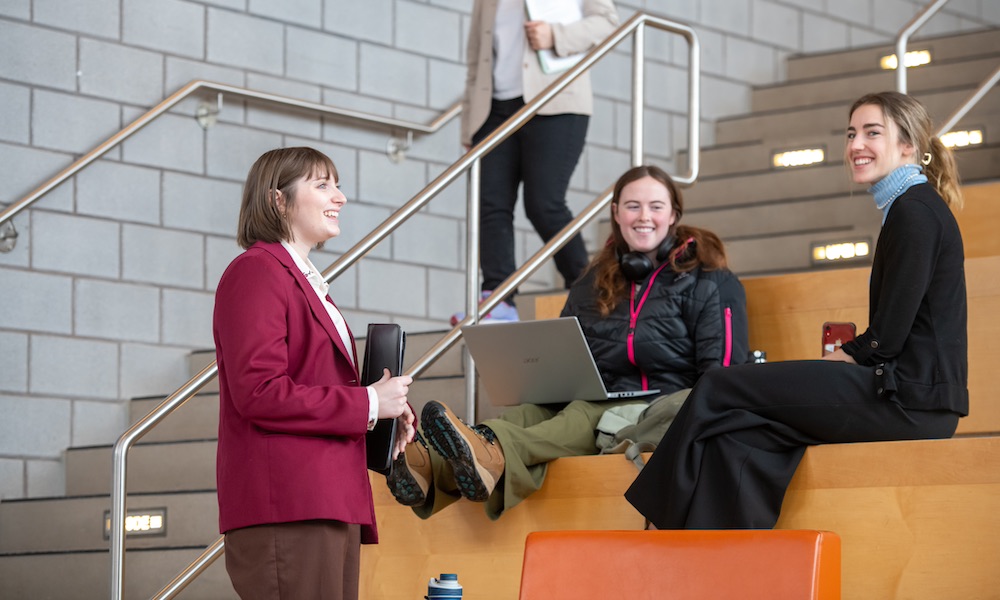 a UPEI student talking to two students in the sustainable design engineering building