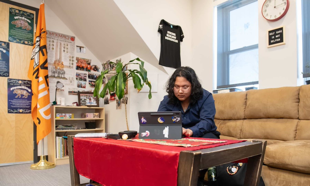 a UPEI student working on a laptop in the Mawi'omi Indigenous Student Centre