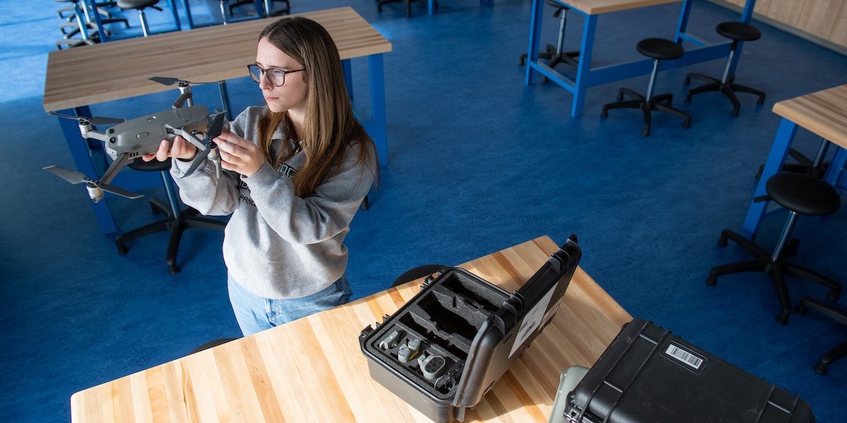 upei student zoe furlotte examining a small drone