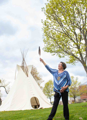 Indigenous language instructor Doris Googoo holding an eagle feather