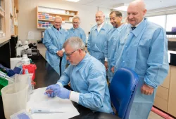 MPs Wayne Easter and Sean Casey watch a demonstration in a dairy research lab at AVC.