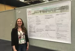 A female student standing in front of a large technical poster