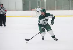 A female hockey player skates down the ice