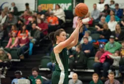 A female basketball player shoots the ball