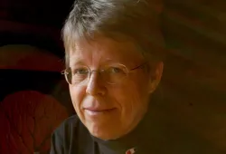 A photo portrait of a woman with shorter hair and glasses