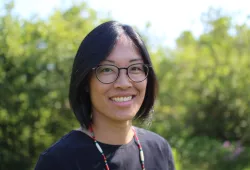 A smiling woman with glasses and dark hair 