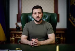 photo of man with hands folded sitting at desk