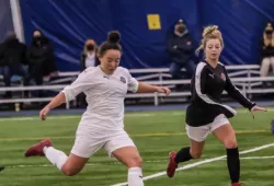 photo of woman kicking soccer ball 