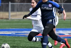 photo of female student athlete dribbling soccer ball