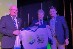 photo of three men holding Canada Games jersey