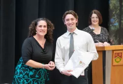 UPEI Faculty of Nursing Interim Dean, Dr. Christina Murray presents nursing student Scott Davis with a scrub coat as Interim Associate Dean, Patrice Drake looks on