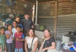 Dr. Libby Osgood (right) and UPEI engineering students Ben McQuaid (standing centre) and Lilly O'Reilly (seated centre), with one of the families that received an eco-stove