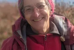 Photo of woman wearing hat with water in the background