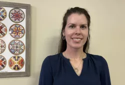 photo of woman standing near a wall hanging