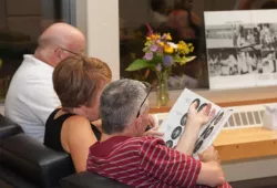 photo of three people looking at yearbooks