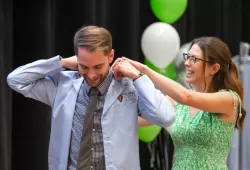 Ryan Subject receives his blue coat from his partner, Brianna Heath