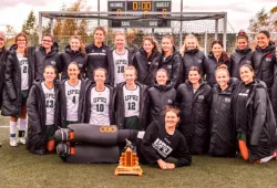 photo of a group of women wearing field hockey uniforms standing on a field