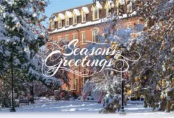 photo of brick building with snow covered trees in foreground