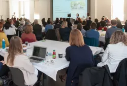 photo of two people presenting to a large group in a meeting room