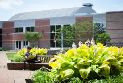 student sitting on a bench in front of brick building