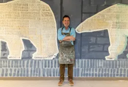 Artist Christopher Griffin stands in front of his mural in the AVC Polar Bear Lounge