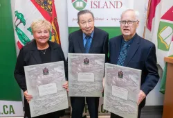 photo of three people holding canvas framed certificates